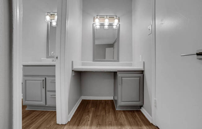 A white bathroom with a vanity and a mirror.