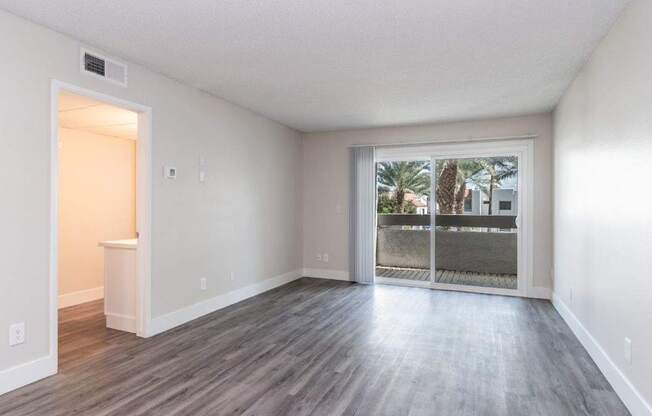 A room with a sliding glass door leading to a balcony.