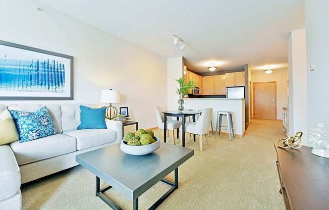A modern living room with a white couch and a grey coffee table.