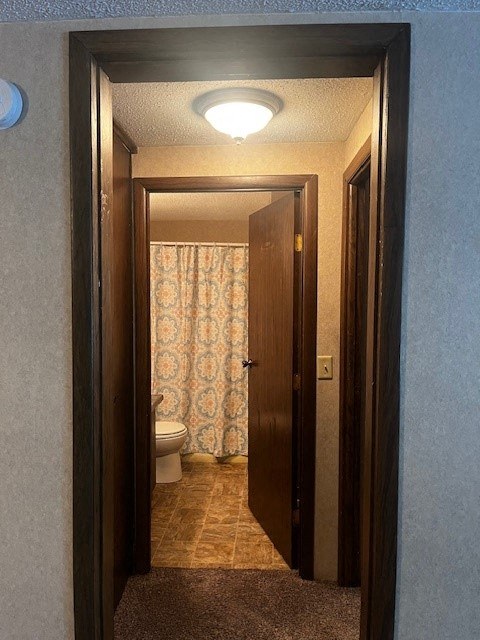 a bathroom with a door open and a toilet