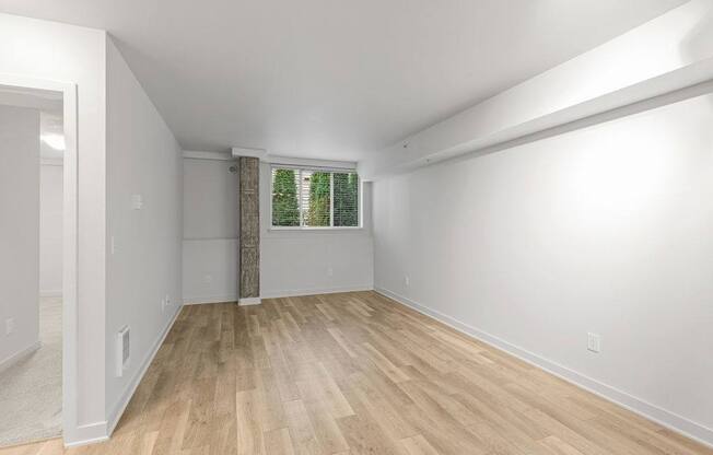 A room with wooden flooring and white walls.