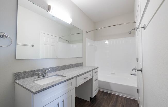 Renovated bathroom featuring granite counters at Center Point Apartments, Indianapolis