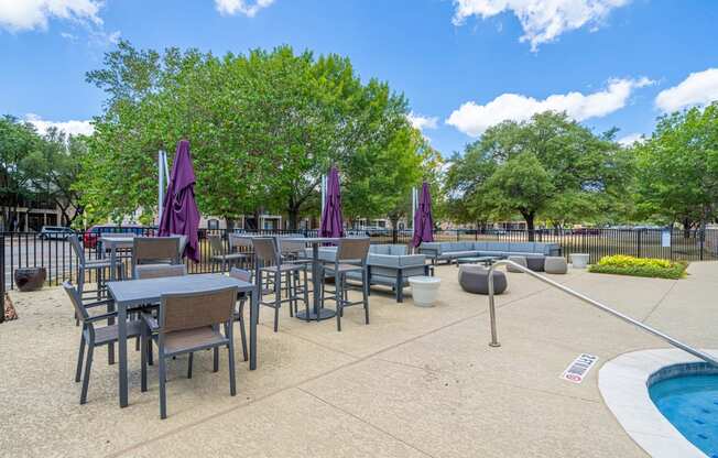 an outdoor patio with tables and chairs and a pool