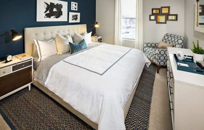 a bedroom with a large white bed and a blue accent wall