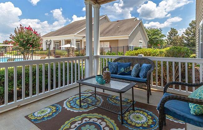 a patio with two chairs and a table on a balcony at Bedford Parke Apartments, Georgia