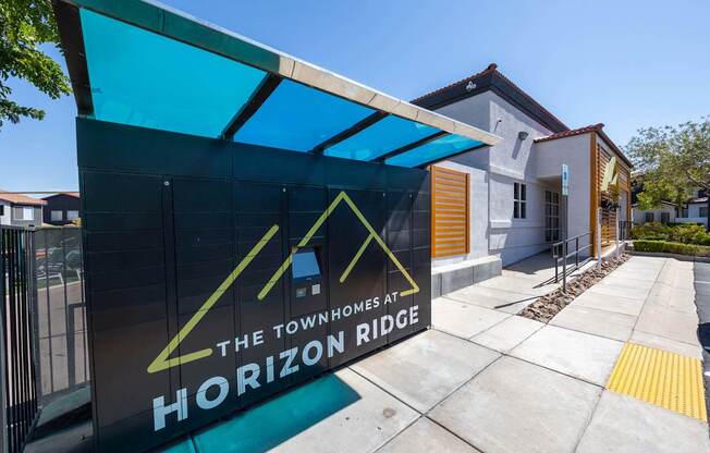 A sign for The Townhomes at Horizon Ridge is displayed in front of a building.