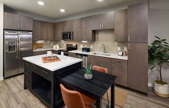 A kitchen with a table and chairs in the middle.