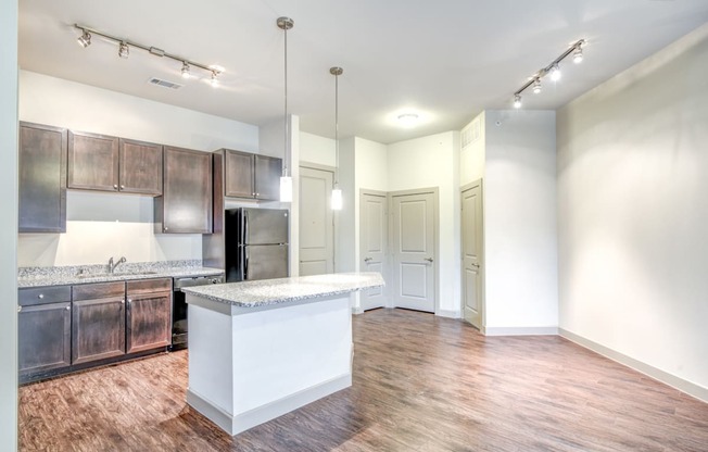 an open kitchen and living room with a large island and wood flooring