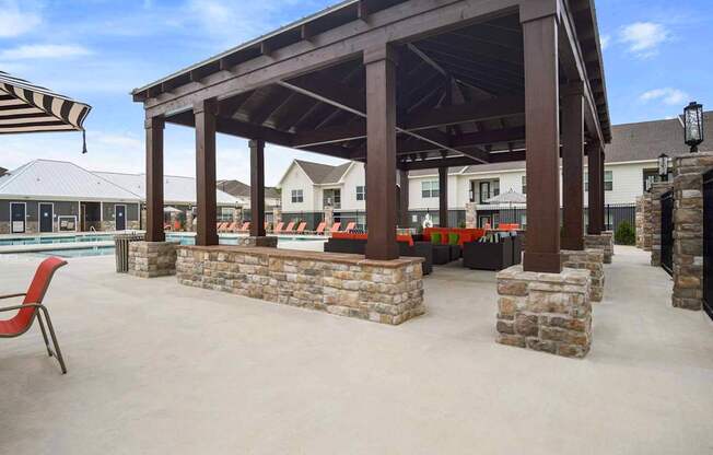 A covered patio area with a pool in the background.