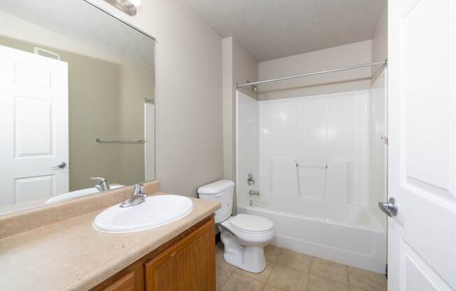 A white toilet sits next to a sink in a bathroom.