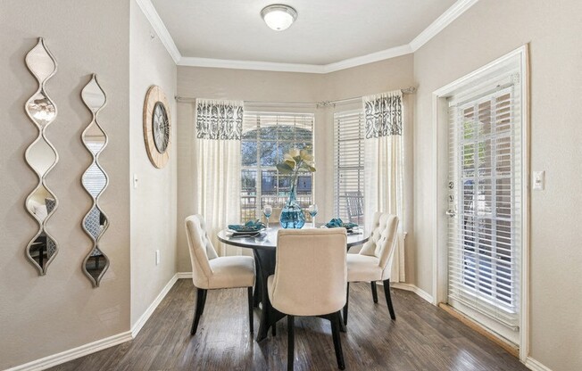 a dining room with a table and chairs and a window