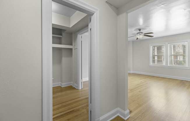 View into a bedroom with hardwood floors and a ceiling fan while also seeing oversized closet space at Charbern Apartment Homes, Seattle, Washington