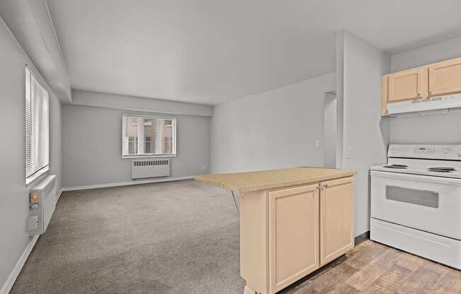 A kitchen with a white stove and a window with blinds