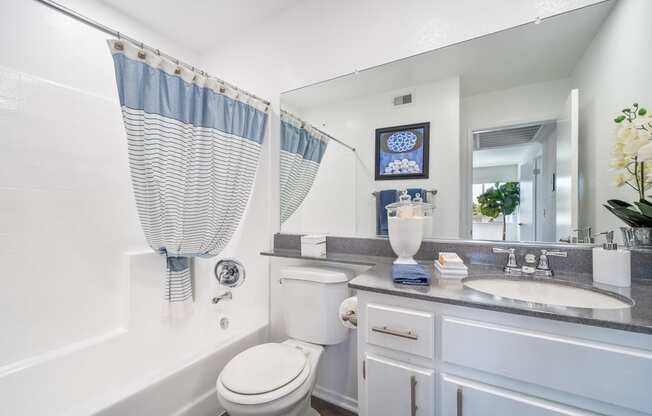 a white bathroom with a white toilet and a tub and a sink