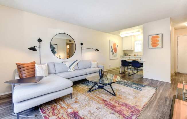 a living room with a couch table and chairs and a kitchen in the background at Renaissance Park Apartments, California