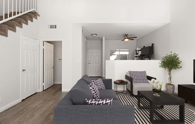 A living room with a grey couch and a black and white striped rug.