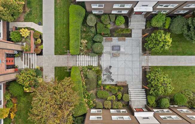 A courtyard surrounded by buildings with a bench and a table in the middle.