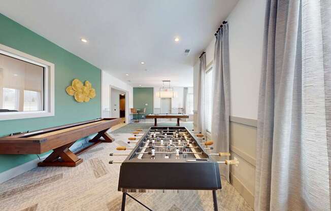 a game room with a pool table, shuffleboard and foosball table