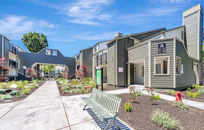 A modern building with a green bench in front of it.