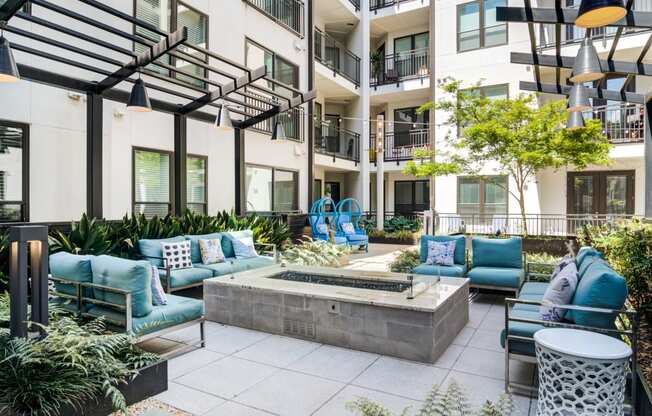 an outdoor lounge area with couches and chairs and a fountain