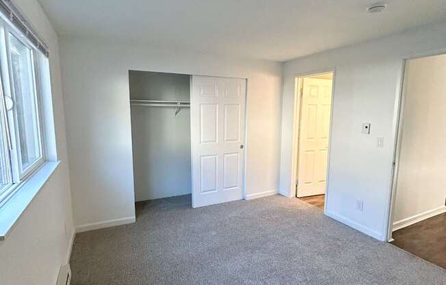 A room with white walls and a grey carpet.