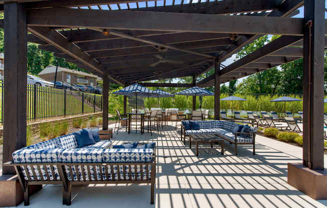 a patio with couches and tables and umbrellas