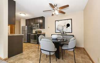 a dining area with a table and chairs and a kitchen with stainless steel appliances. Anoka, MN Dellwood Estates