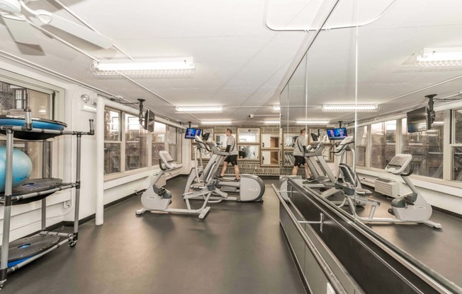 a gym with cardio machines and weights in a building