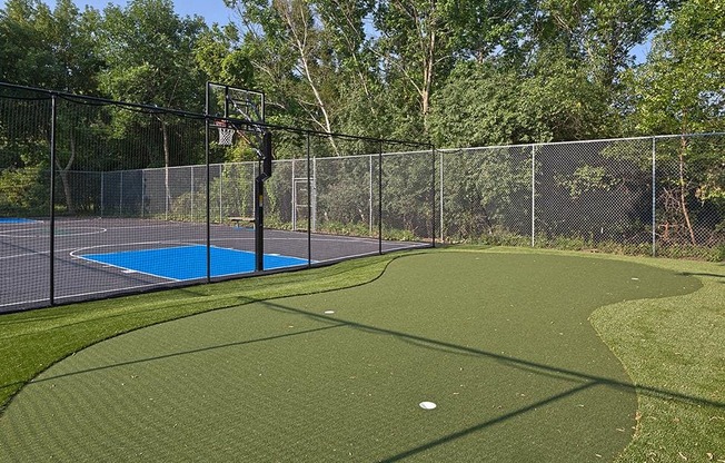 Outdoor recreation area with a putting green and basketball court