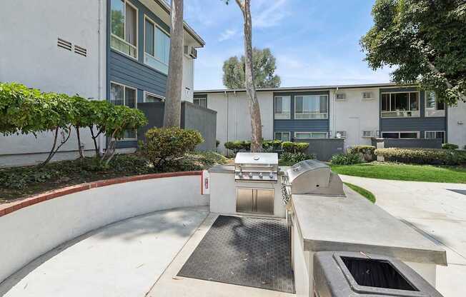 A modern outdoor kitchen area with a grill and sink.