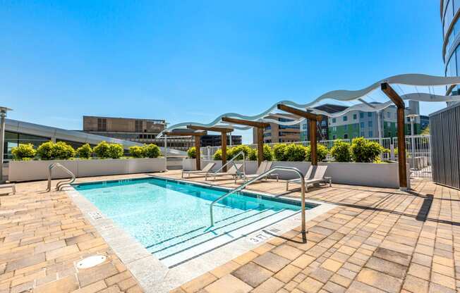 the pool on the rooftop of a building with chairs and a swimming pool