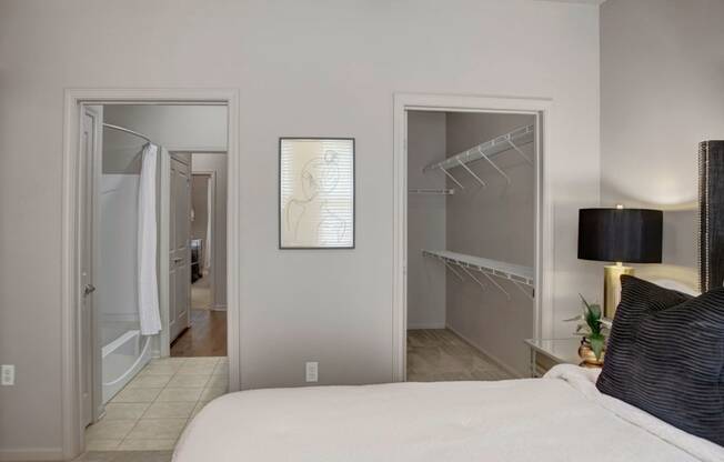 a bedroom with a large bed and a closet with a mirrored door