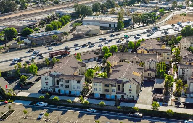 an aerial view of a neighborhood with cars on the street and houses