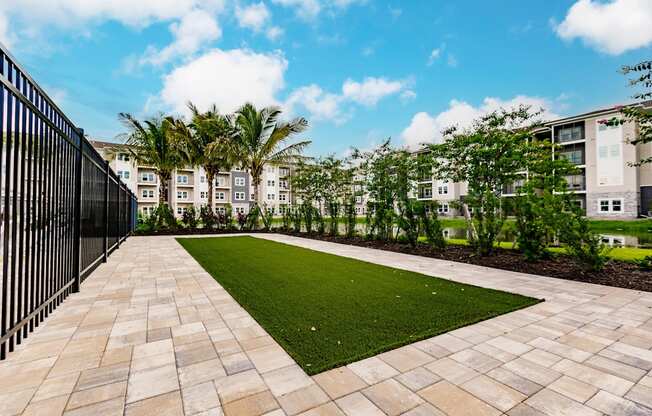 a courtyard with grass and trees in front of Vantage apartment buildings
