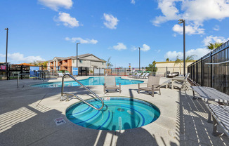 A pool with a slide and sun loungers.