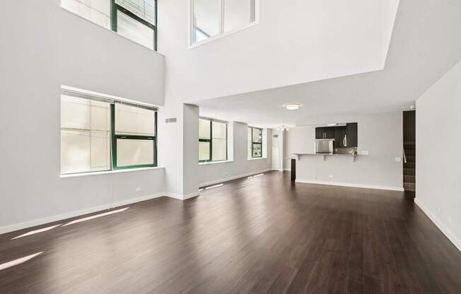 A spacious room with wooden floors and white walls.