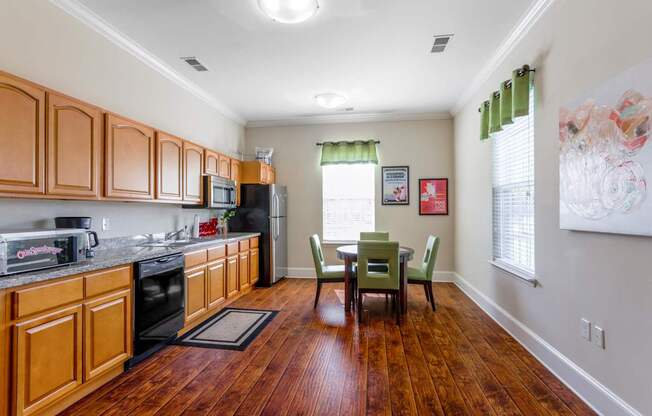 A kitchen with wooden cabinets and a dining table with chairs.