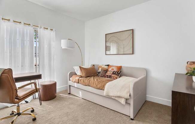 A living room with a white couch and a brown chair.