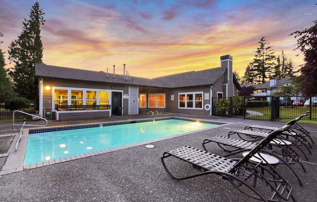 A house with a pool in front of it.