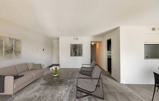 A living room with a grey couch, a coffee table, and a painting on the wall.