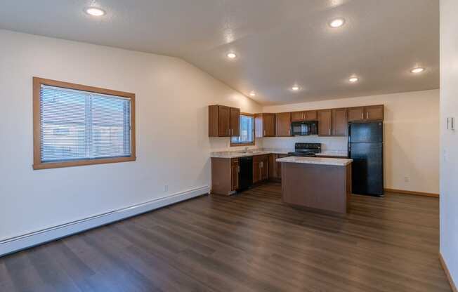 a kitchen and living room with two windows on the left. Fargo, ND Westwood Apartments