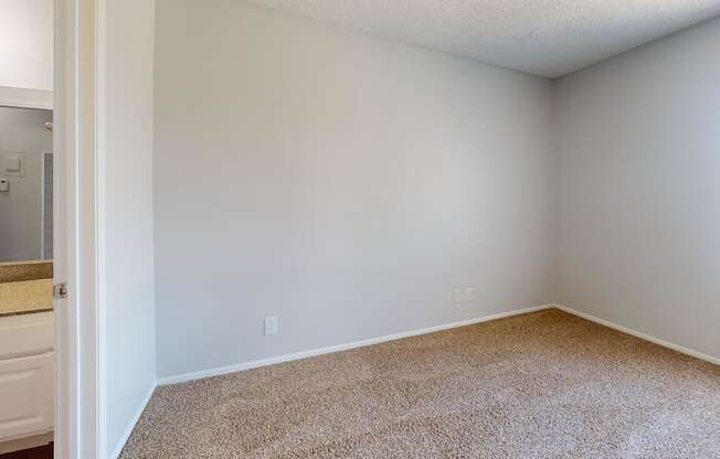 an empty room with a bathroom and a window