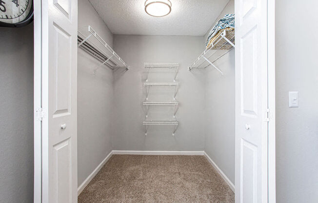 an empty closet with shelves and a wall clock