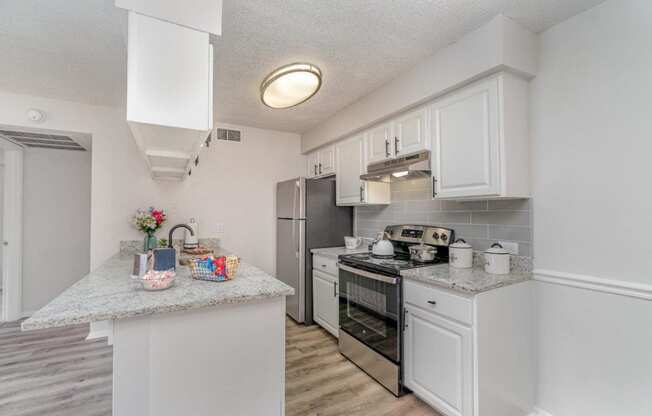 a kitchen with white cabinets and a counter top