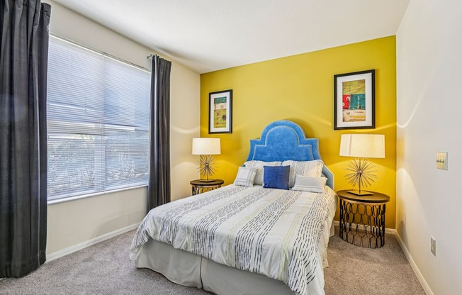 A bedroom with a large bed and a blue headboard.