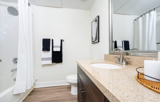 A bathroom with a white toilet, a sink, and a mirror.