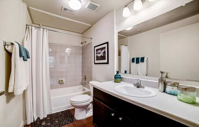 a bathroom with a white sink and toilet next to a bathtub with a shower curtain