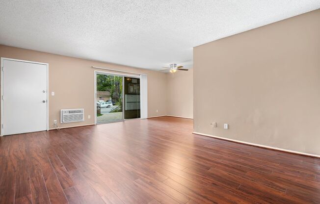 a living room with hardwood floors and a sliding glass door to a patio