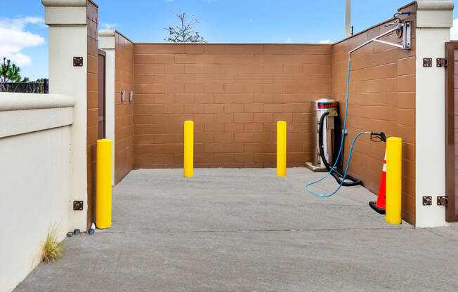 a gas station with a brick wall and yellow pillars