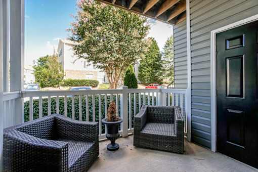 A patio with two chairs and a table.